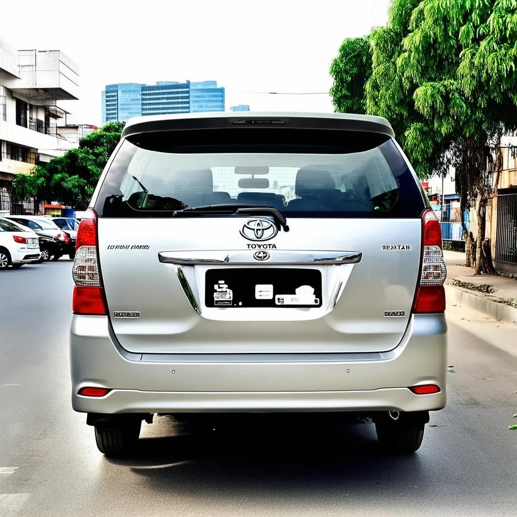 Xe Toyota Innova 7 chỗ cũ màu bạc sang trọng, đậu trên phố