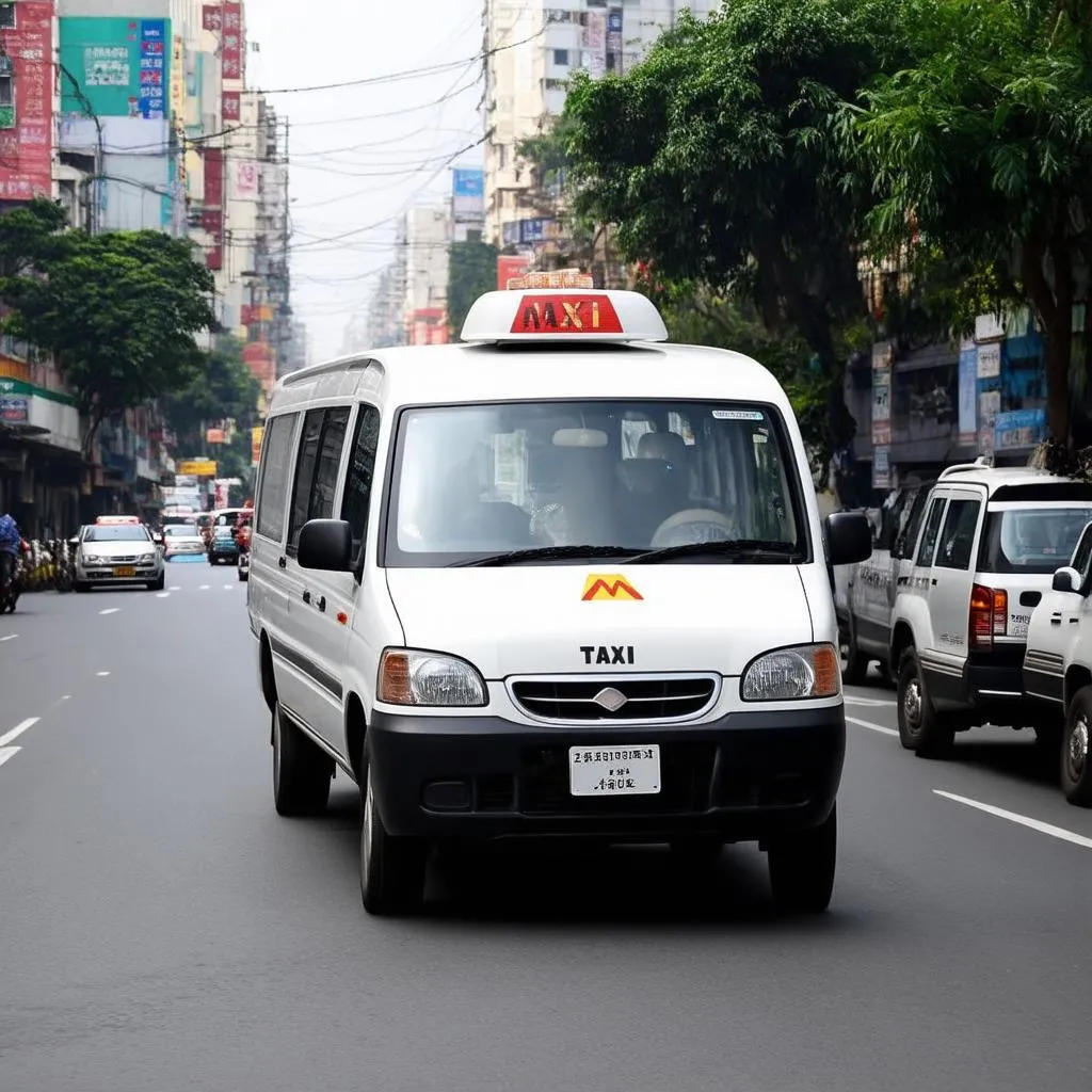 Xe tải van M Taxi Bình Anh 3 đang di chuyển trên đường phố