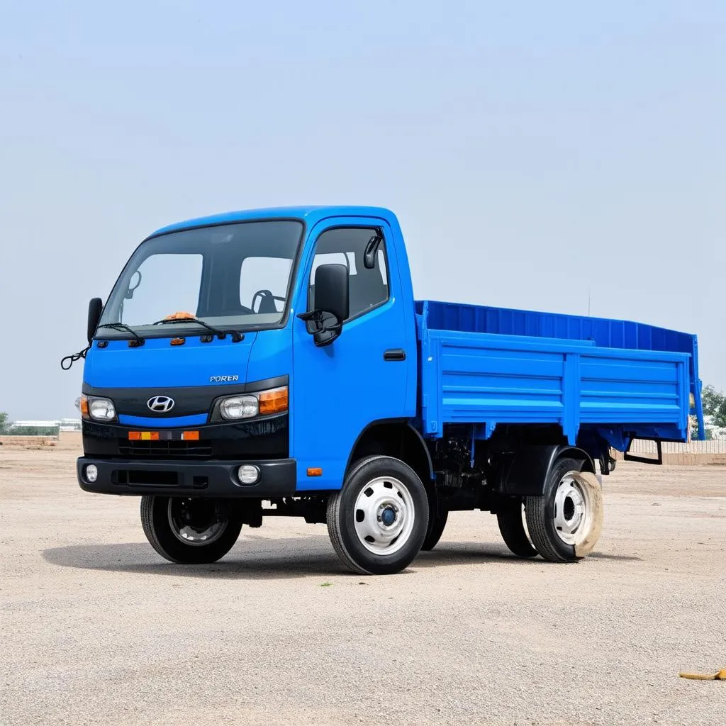 Xe tải Hyundai Porter 1.2 tấn màu xanh đang đậu trên bãi đất trống